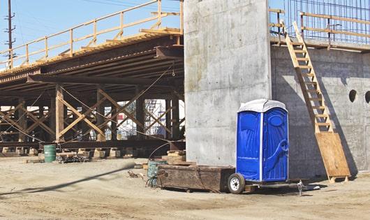 porta potties set up for workers’ use at a busy construction site